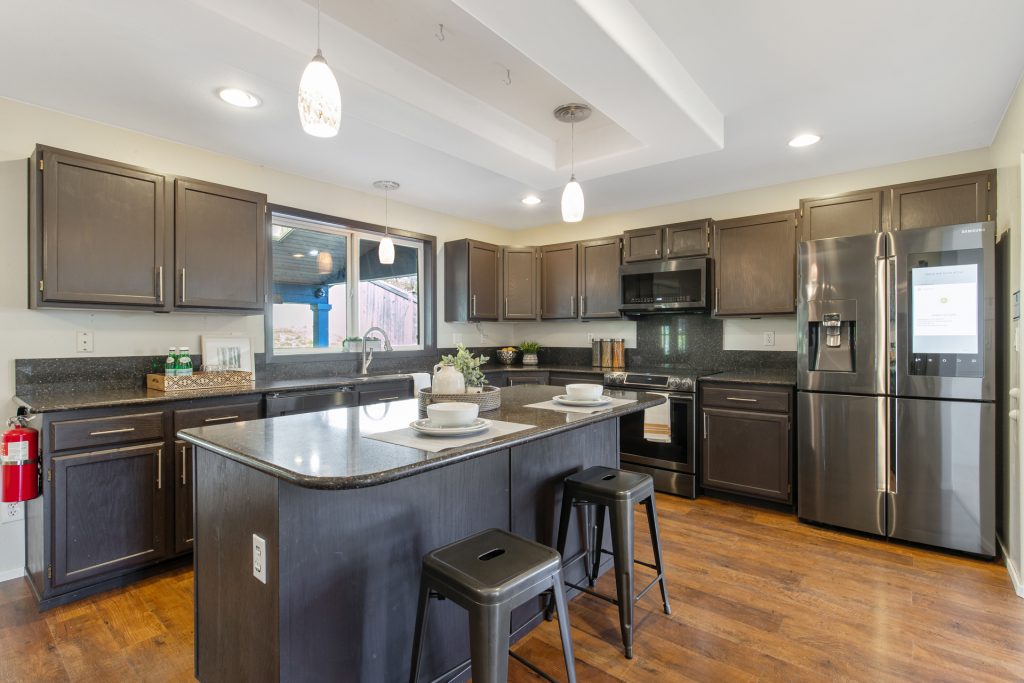 The dining room flows into the updated kitchen with an eat-in island, freshly painted cabinets, slab granite counters, new hardware and new appliances. 