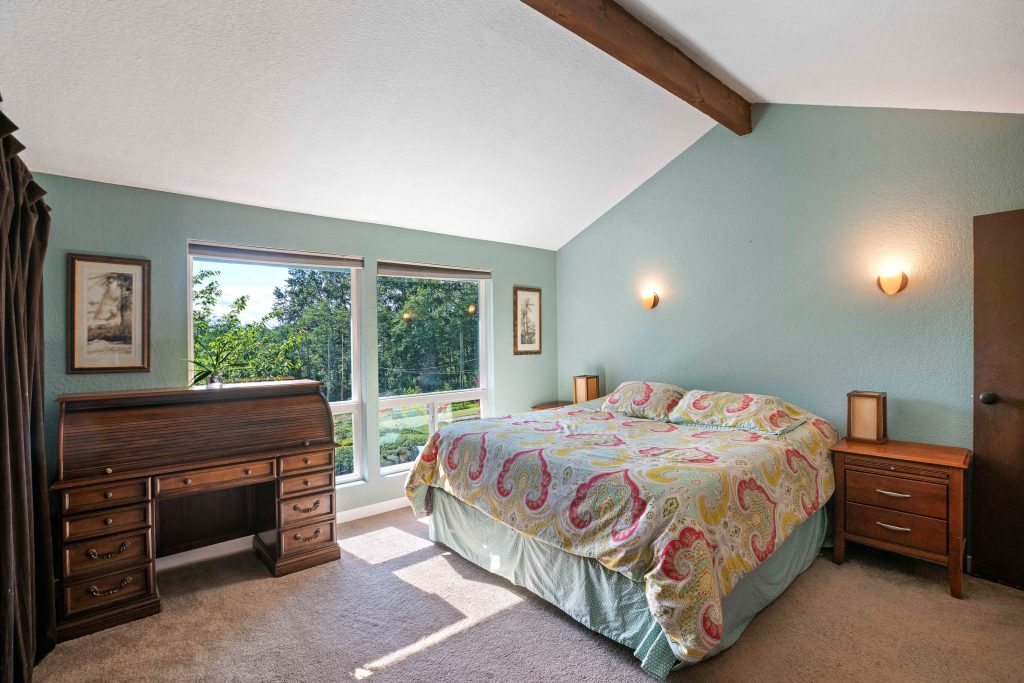The master bedroom is also found on the upper level and also boasts vaulted ceilings and large picture windows. It can accommodate a king-sized bed plus extra furniture as well.