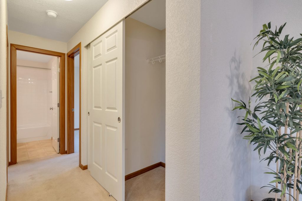 There are two large storage closets in the hallway. The main full bath is straight ahead and the smaller of the two bedrooms is on the right.