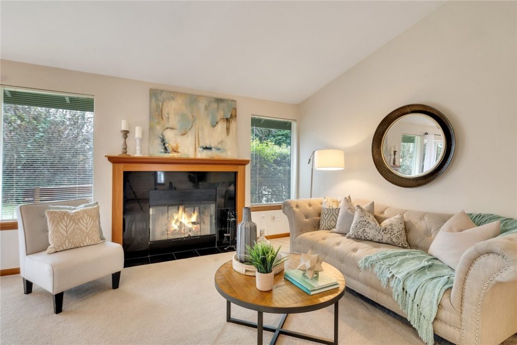 The living room features a wood-burning fireplace and vaulted ceilings.