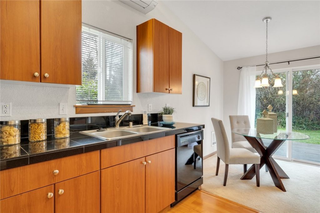 The kitchen features granite tile countertops and beautiful wood cabinets.