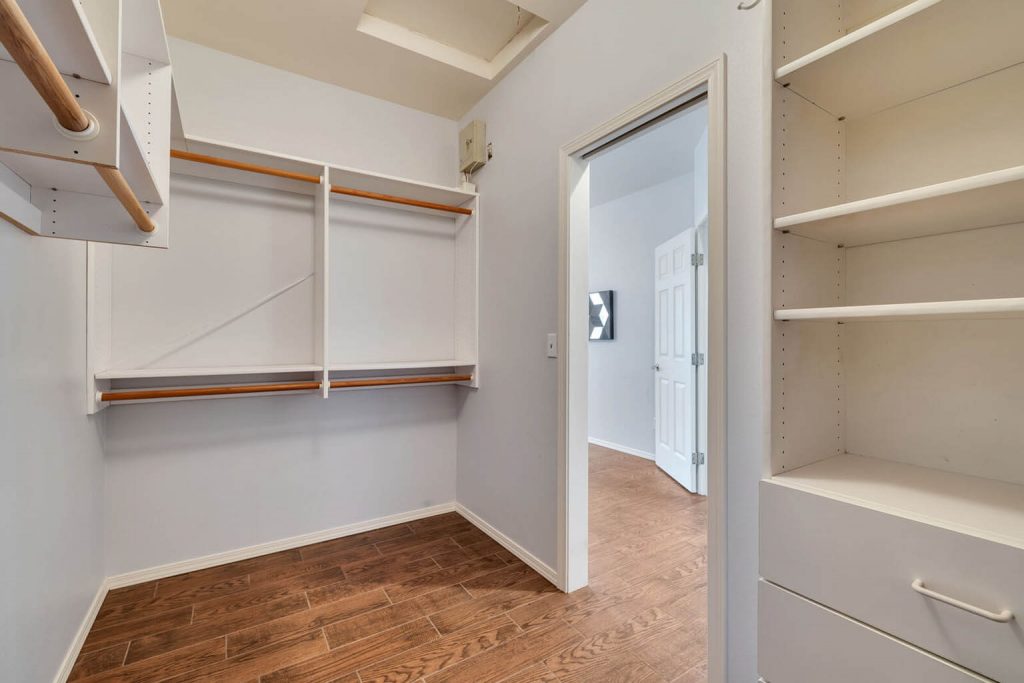 The generous walk-in closet features a nice organizer system.