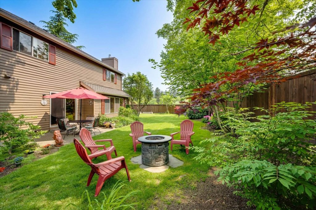 Offering a lovely patio area and a firepit pad (firepit does not stay), this lovingly landscaped back yard provides plenty of spots for backyard entertaining.